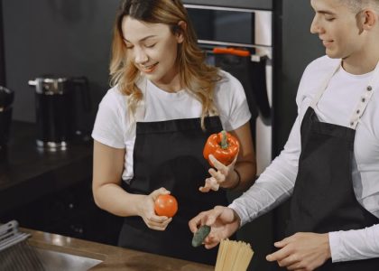 Young couple preparing meal in a modern kitchen, smiling and enjoying time together.