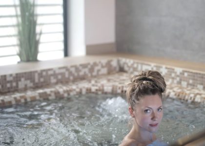Woman enjoying a relaxing soak in a modern indoor spa jacuzzi.